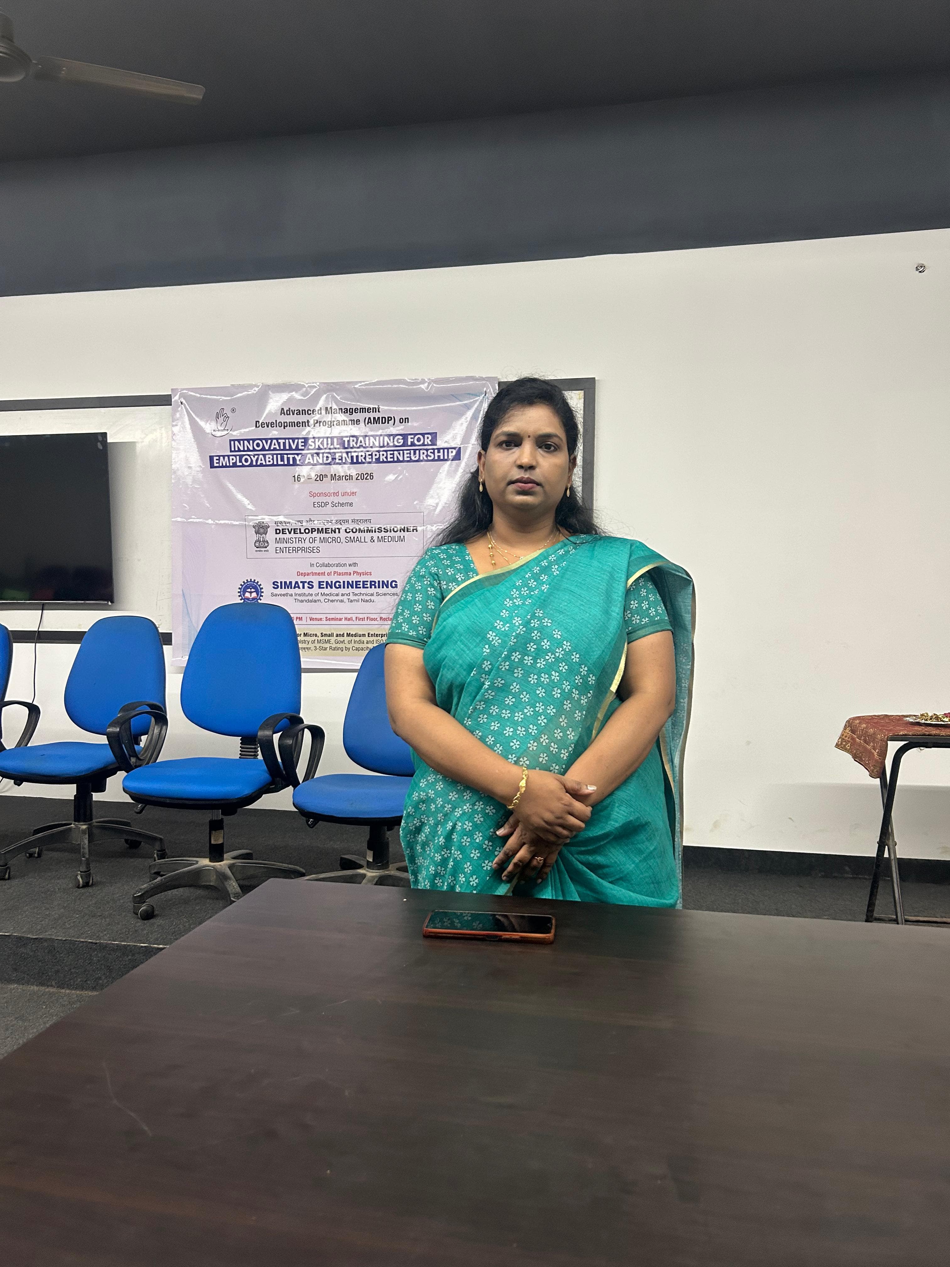 Facilitator standing in front of a banner at a skill development training programme