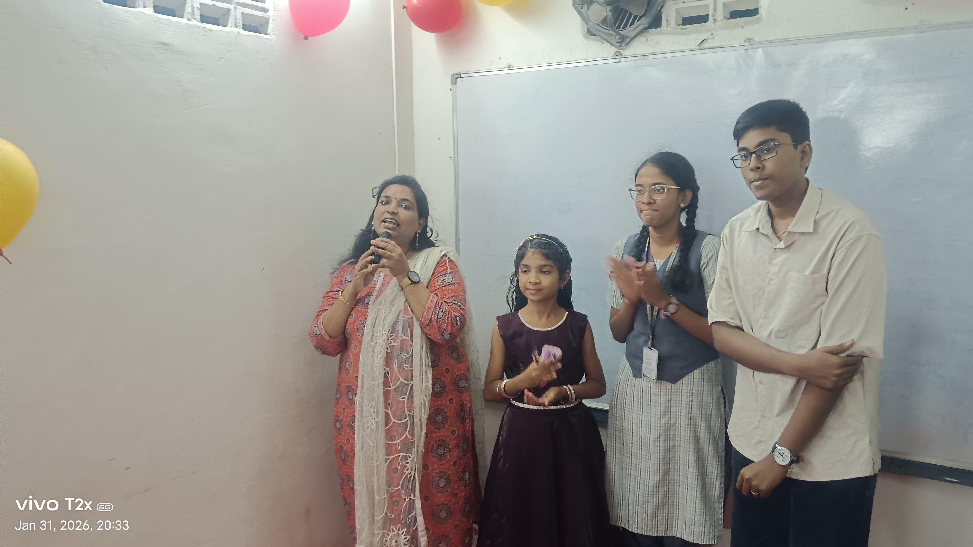 Facilitator and students at a balloon-decorated event
