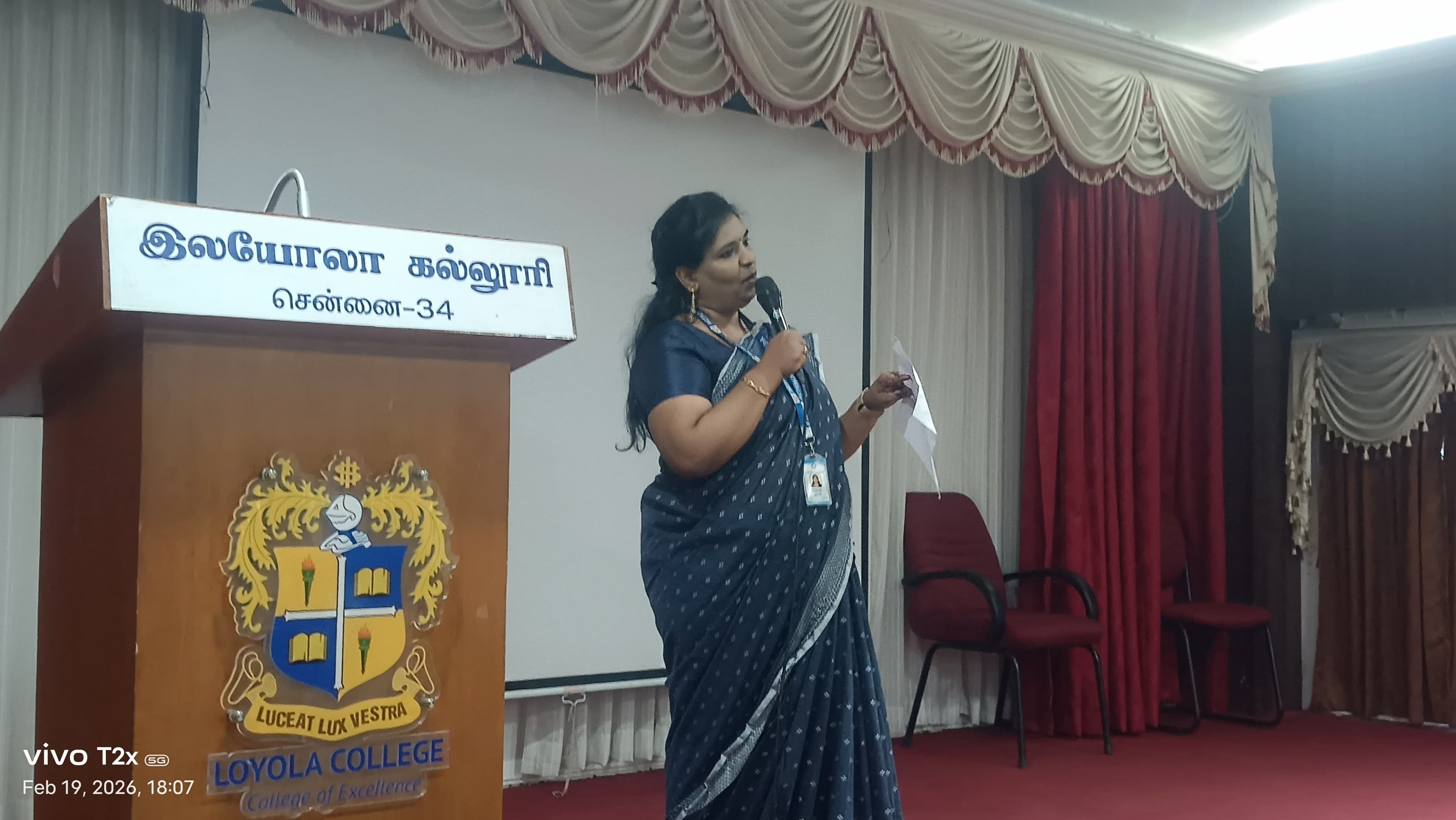Facilitator speaking at a college auditorium podium