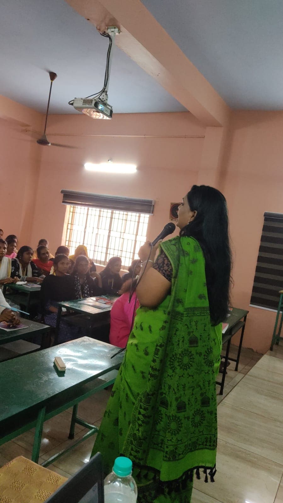 Facilitator addressing students with a microphone in a classroom