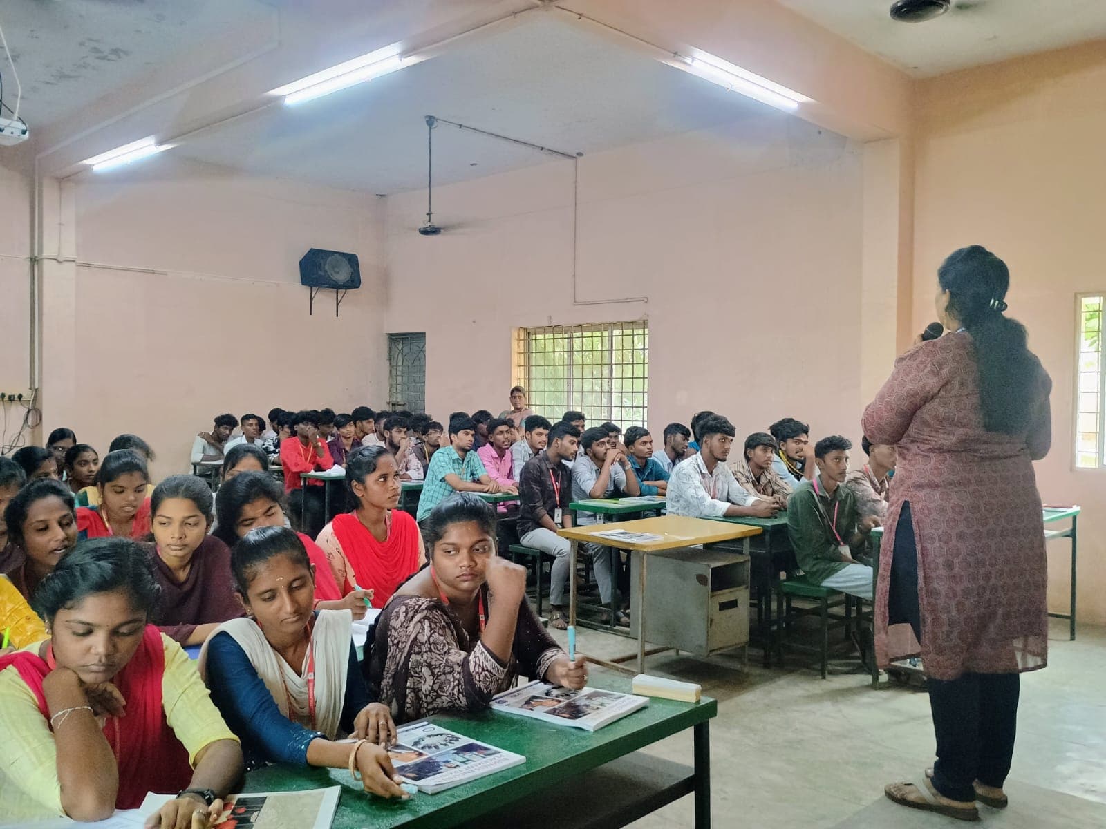 Facilitator addressing a full classroom of college students