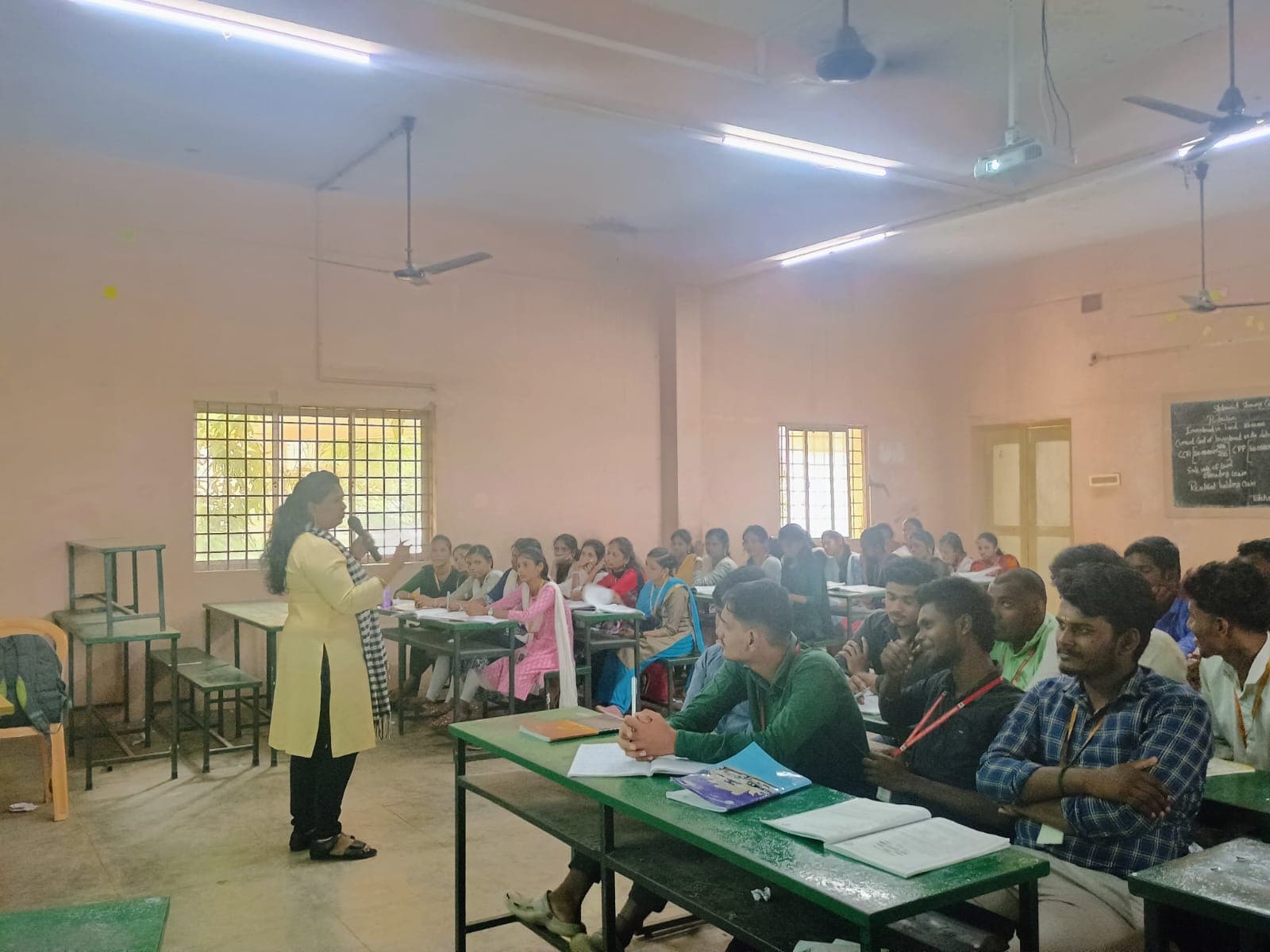 Facilitator addressing a full classroom of college students
