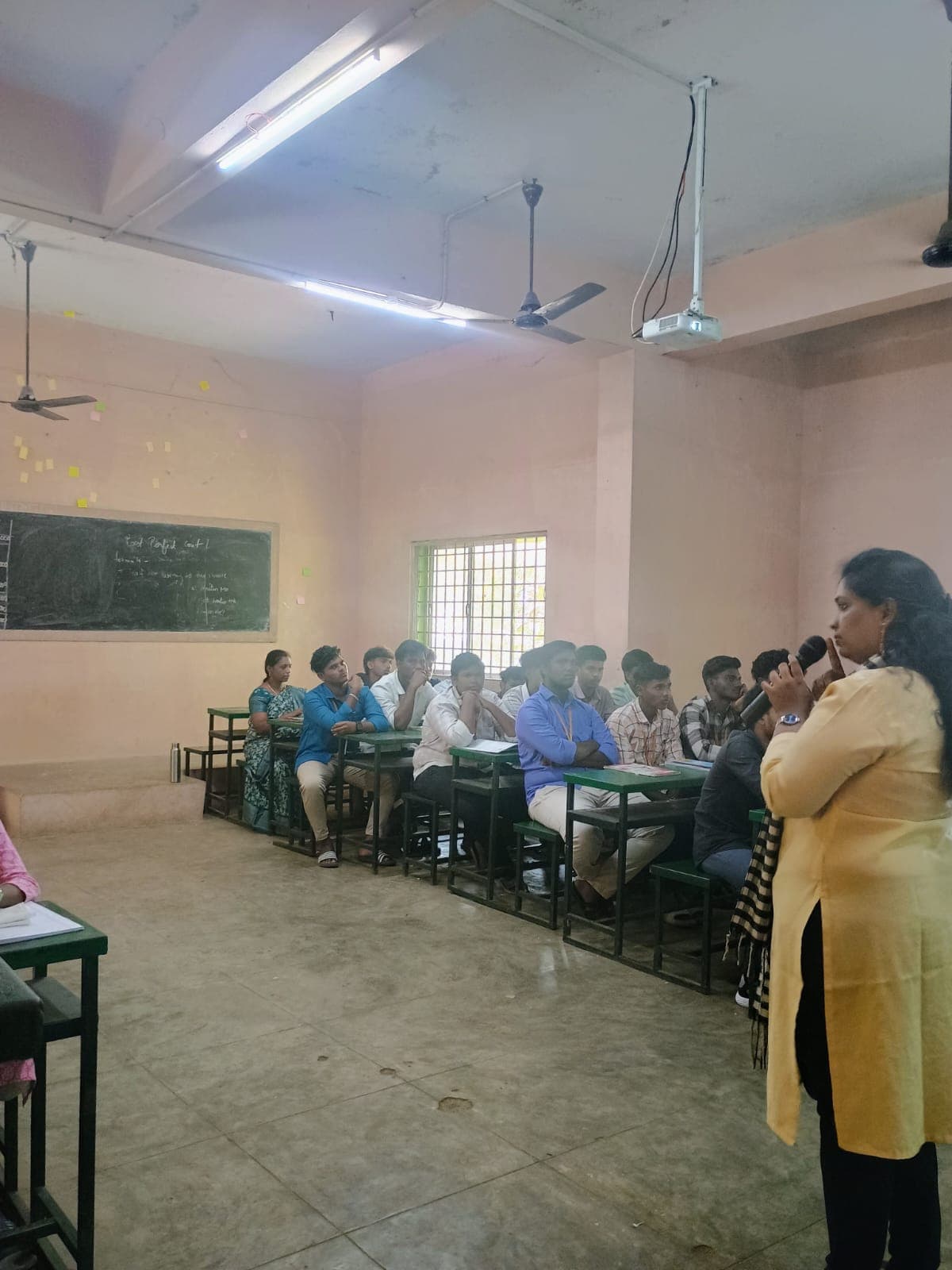 Facilitator addressing a full classroom of college students
