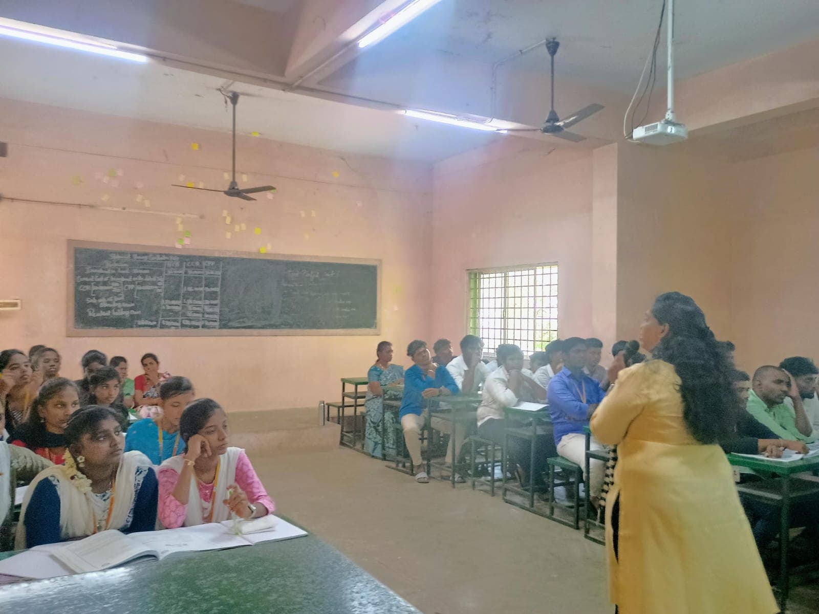 Facilitator addressing a full classroom of college students