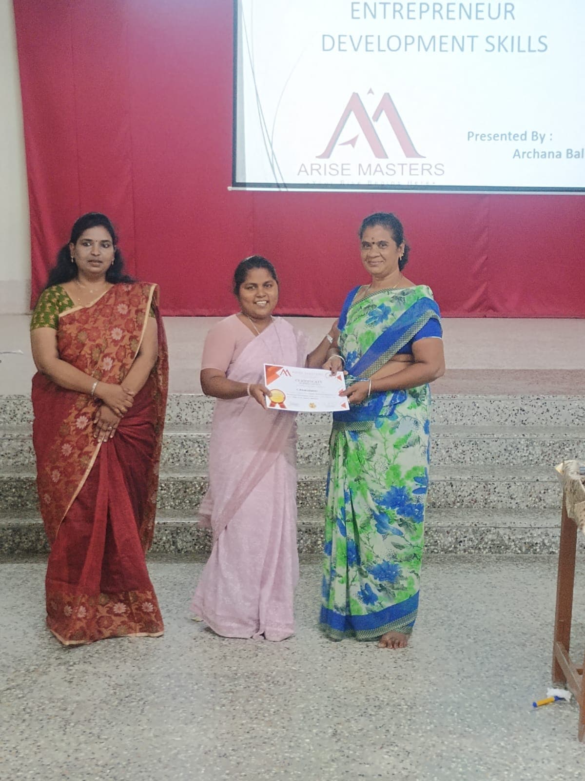 Certificate being presented on stage at an entrepreneurship training event