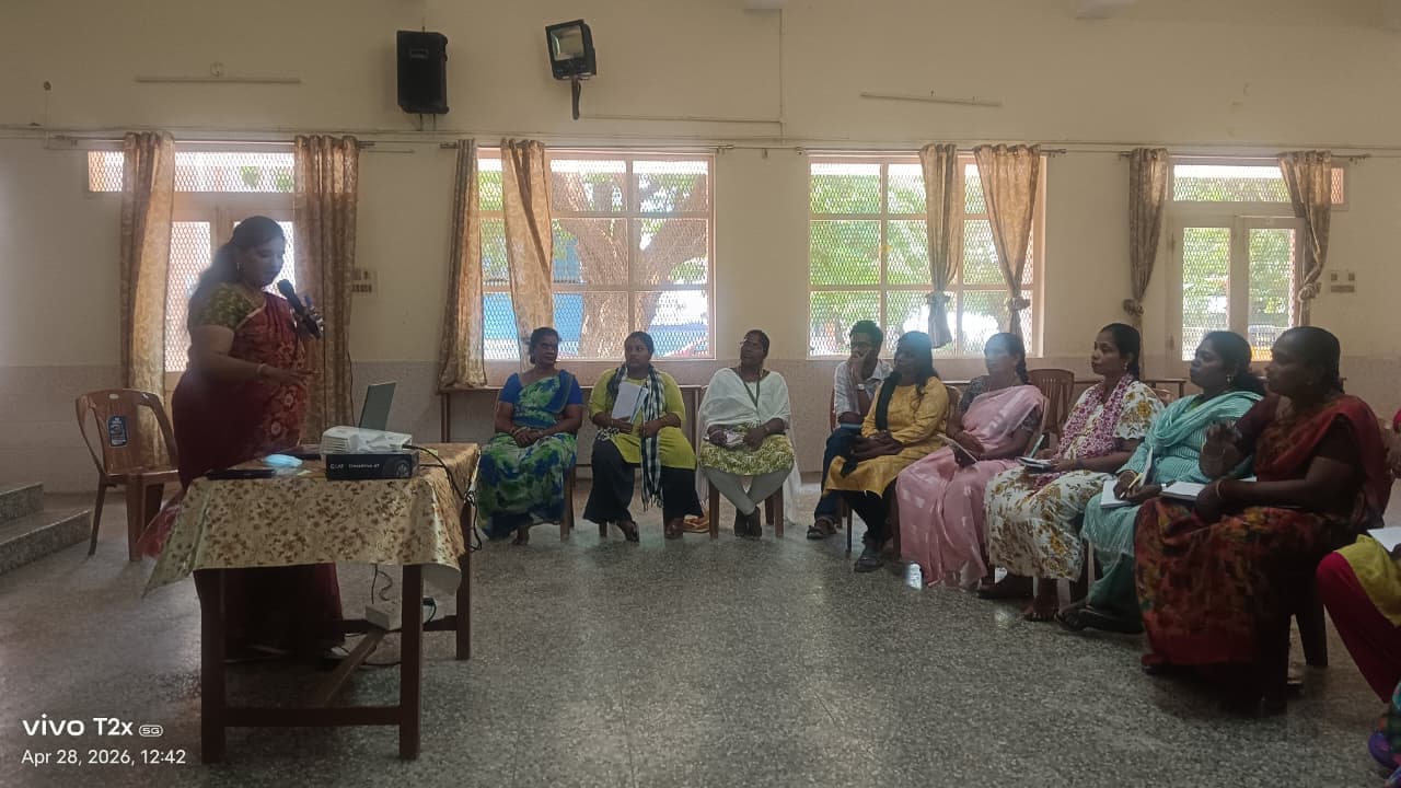 Facilitator addressing a seated group at a community training session