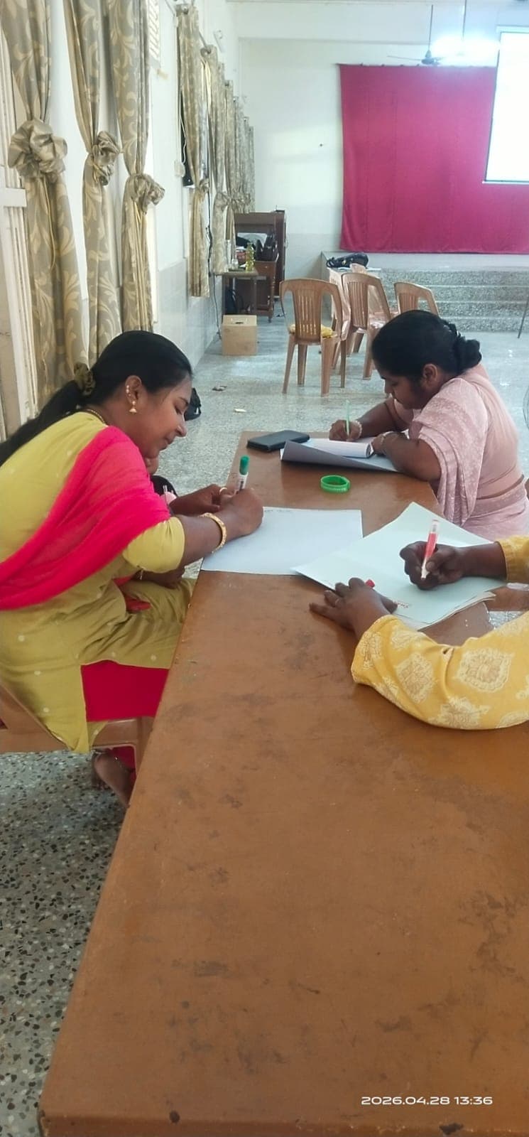 Participants writing at a table during a community workshop