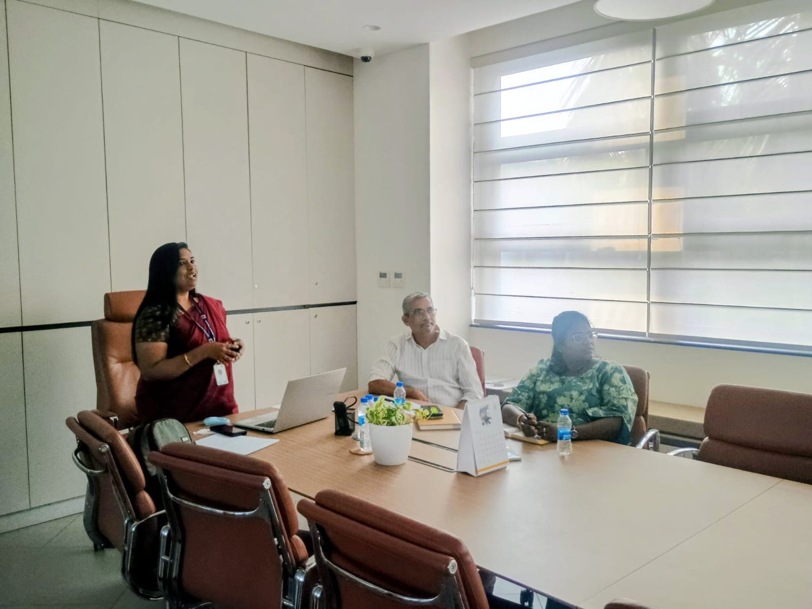 Facilitator presenting to a small group in a corporate boardroom