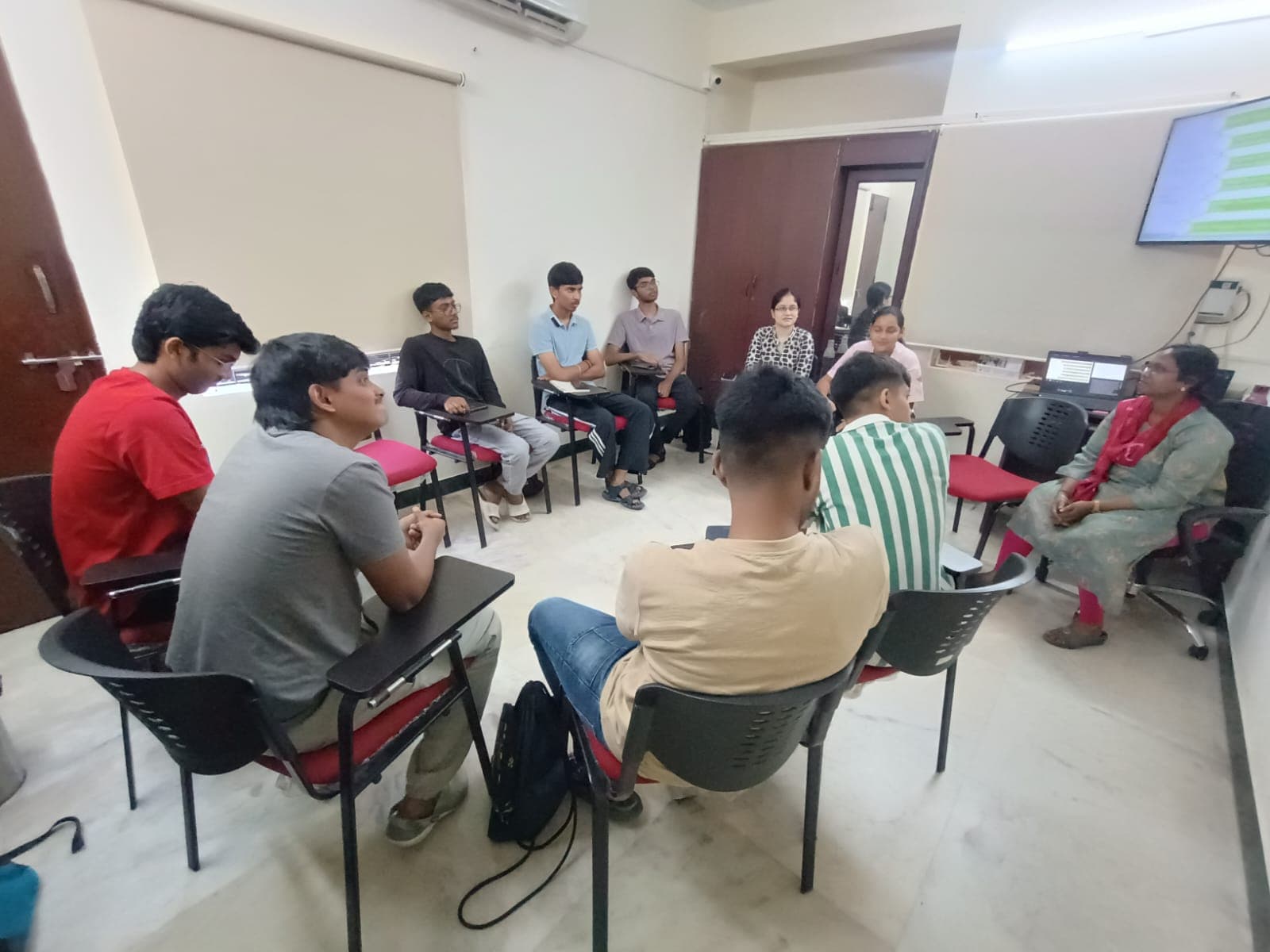 Participants seated in a circle writing during a community workshop